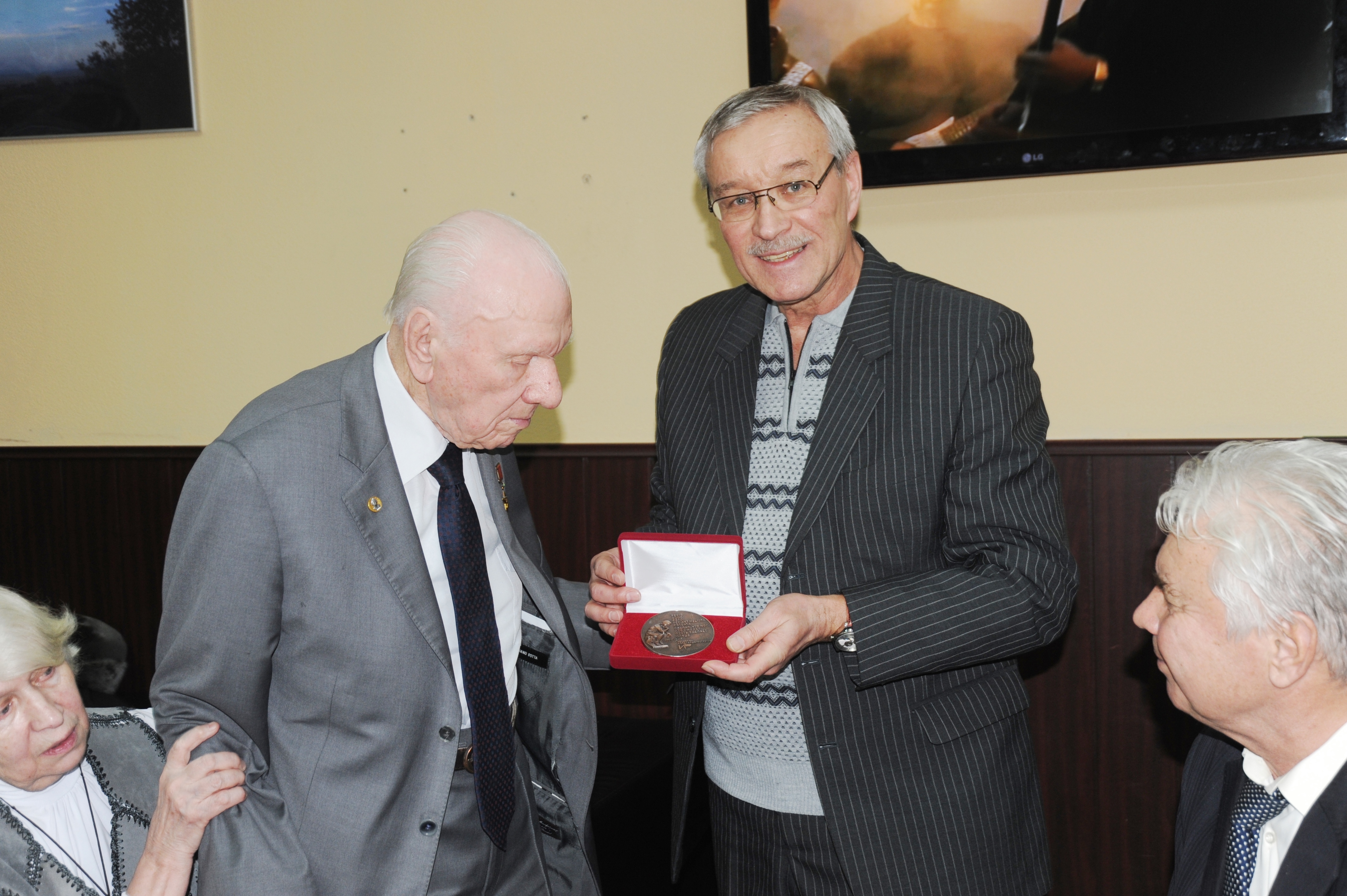 В.Бородин вручает награду А.Савину (слева).